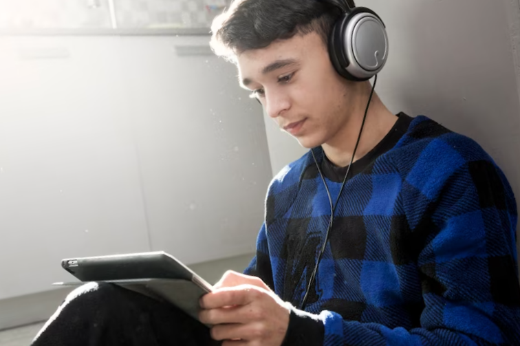 Teenager using tablet of floor