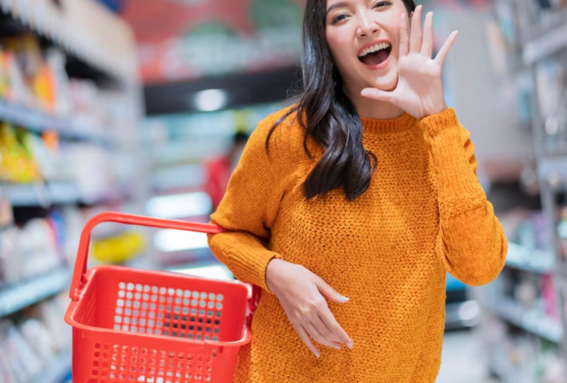 Happiness cheerful exited asian female woman casual cloth hand hold empty shopping basket hand gesture announce good news or new promotion to cameraasian female smiling in supermarket groceries mall
