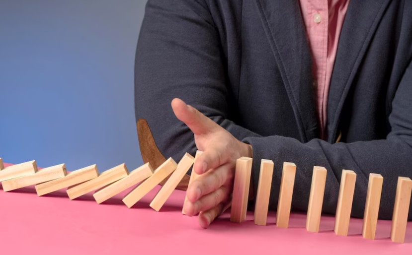 wooden blocks falling representing economy
